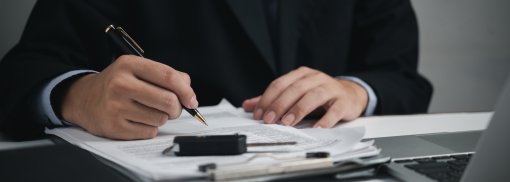 © Autohändler, Geschäftsmann, unterzeichnet das Autoversicherungsdokument. Autokauf, Kredit- und Versicherungskonzept. Digitale Autozulassung ab September 2023 - was ist neu?