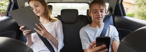 © Teenager-Kinder mit digitalen Geräten auf Familien-Roadtrip - monkeybusiness Lange Autofahrten: So halten Sie die Kinder bei Laune