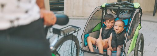 © Zwei Kinder hinten auf einem Fahrradanhänger. - twnty20photos So finden Sie den richtigen Anhänger für ihr Fahrrad