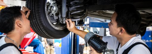 © Zwei Mechaniker überprüfen die Federung des Autos - thananit_s Federbruch: Anzeichen und Ursachen